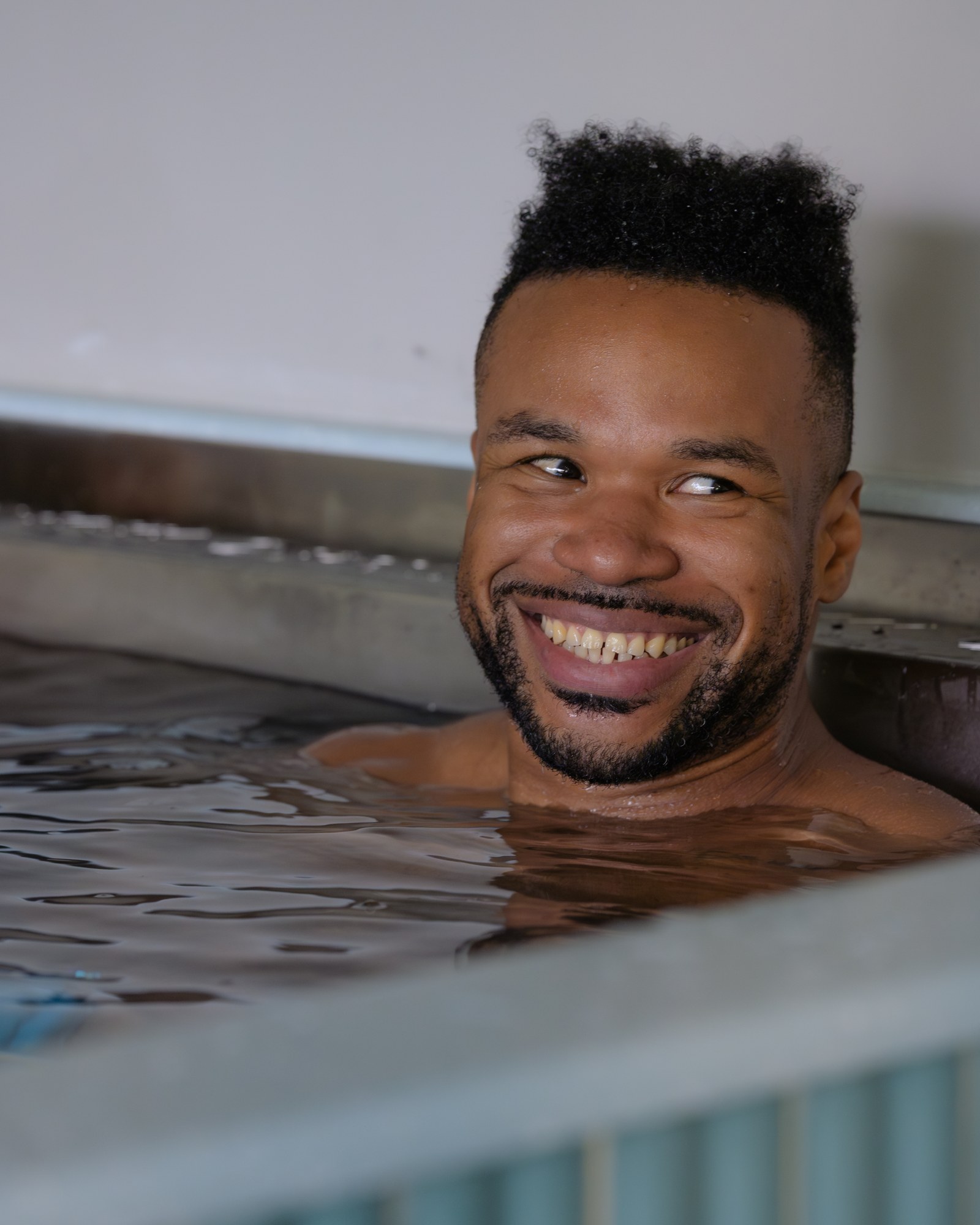 A member smiling in the cold plunge
