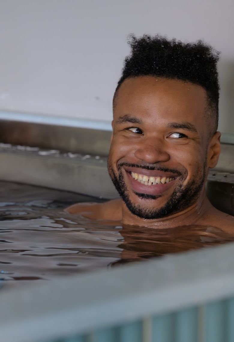 A member smiling in the cold plunge